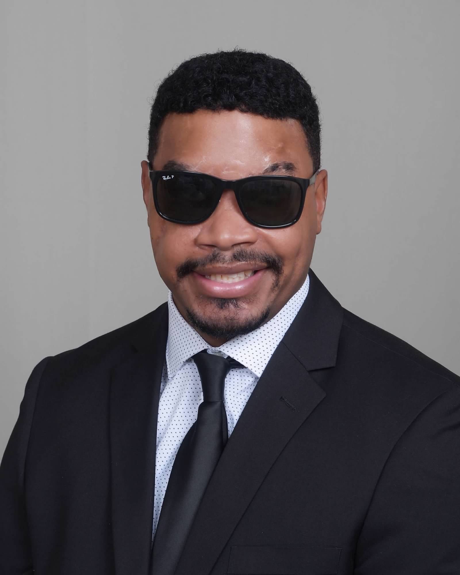 Kijuan Amey smiling with a white collared shirt